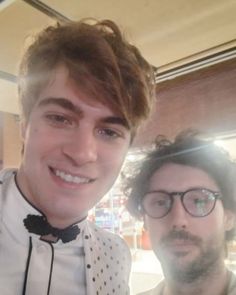 two men standing next to each other wearing bow ties