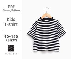 a black and white striped t - shirt hanging on a hanger with the text kids's t - shirt