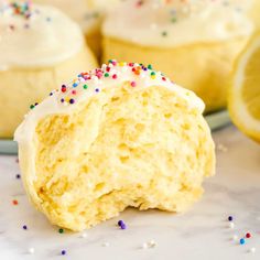 a lemon cupcake with white frosting and sprinkles on a plate