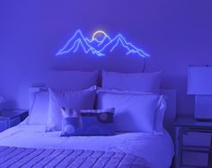 a bed with white sheets and pillows in front of a purple light that is on the wall