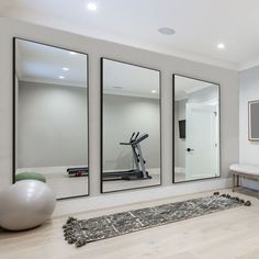 there are mirrors on the wall in this home gym area with exercise balls and an exercise bike