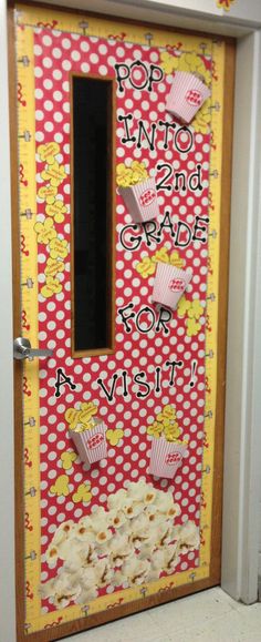 a door decorated with red and white polka dot paper, popcorn pop into 2nd grade for a visit