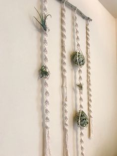 three ropes hanging on the wall with flowers attached to them