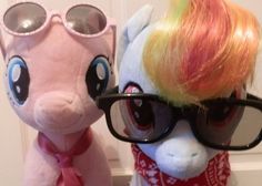 two stuffed animals wearing glasses and scarfs next to each other