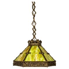 a stained glass lamp hanging from a chain on a light fixture with an ornate design