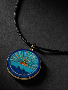 Handcrafted to be a ""talisman of energy""; Jacquie Aiche's gold pendant necklace is strung with black cord and features a shining seascape. The intricate design is inlaid with pieces of turquoise and lapis. Luxury Blue Medallion Jewelry, Luxury Adjustable Blue Necklace, Blue Coin Pendant Jewelry, Blue Jewelry With Detachable Round Pendant, Blue Jewelry With Detachable Pendant, Blue Engraved Amulet Jewelry, Blue Engraved Amulet Style Jewelry, Blue Medallion Jewelry With Large Pendant, Blue Medallion Pendant Jewelry