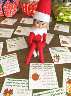 an elf sitting on top of a table next to christmas cards