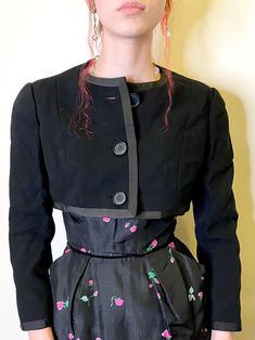 "This is great black wool cropped jacket by designer Geoffrey Beene! Buttons up the front and has a grosgrain ribbon trim. Fully lined with a satiny lining.  Really a great designer jacket! The quality and craftsmanship is certainly shown in the way the button holes are finished and the exquisite couture cut of the jacket.  This was made in the early part of the designers label, early to mid 1960s. Measurements are approximately:  36\" bust  13.5\" in length from back collar to hem 15\" across t Spring Wool Cropped Jacket, Spring Cropped Wool Jacket, Fitted Wool Cropped Jacket For Spring, Tailored Cropped Jacket For Evening In Spring, Tailored Black Cropped Jacket For Evening, Black Tailored Cropped Jacket For Evening, Jacket Fabric, Designer Jacket, Geoffrey Beene