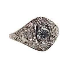 This antique piece was handcrafted sometime during the Edwardian design period (1900-1920). Delicately crafted in exquisite platinum, this whimsical ring captures the essence of the Edwardian period with its timeless beauty and intricate details.   At the heart of this mesmerizing piece are three vertically aligned diamonds, each one a celestial star illuminating the heavens. These brilliant gemstones radiate a joyous brilliance, symbolizing the past, present, and future of your love story. Surrounding them are eight accent diamonds, sparkling like ethereal stardust, enhancing the ring's allure.   But it's the fine artistry of the ring that truly sets it apart. Adorning the platinum band is an enchanting display of filigree, reminiscent of delicate lacework floating on a summer breeze. Eve Art Deco Oval Platinum Diamond Ring, Heirloom Platinum Diamond Ring With Center Stone, Art Deco White Gold Cluster Ring In Platinum, Art Deco Platinum Ring With Center Stone, Antique Platinum Diamond Ring With Center Stone, Art Deco Oval Cluster Ring In Platinum, Art Deco Platinum Diamond Ring With Rose Cut Diamonds, Antique Platinum Cluster Ring, Antique Single Cut Diamond Ring For Formal Occasions