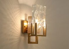 a wall light that is on the side of a wall with two lights attached to it