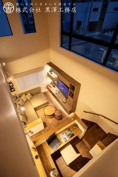 an aerial view of a living room and dining area from the top floor looking down