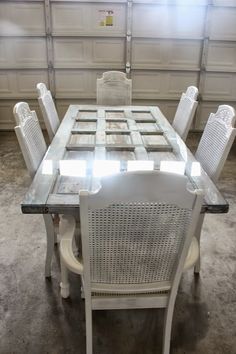 a white table and chairs in a room with a light coming through the window behind them