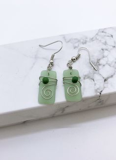 Seaglass Hamilton gold earring Living on Hawaii have given us the inspiration for our beautiful jewelry design.  Each piece of our jewelry is beautiful made to reveal the unique style of the Hawaiian Islands.  They are also the perfect little gift for your ohana (family), friends or your special someone. Nickel Free Glass Jewelry In Minimalist Style, Minimalist Nickel-free Glass Jewelry, Minimalist Glass Earrings For Gift, Minimalist Green Glass Jewelry, Wire Wrapped Dangle Earrings For Gift, Glass Drop Earrings For Gift, Elegant Recycled Glass Earrings With Ear Wire, Minimalist Glass Jewelry With Ear Wire, Unique Wire Wrapped Earrings As A Gift