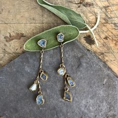 These earrings are inspired by the rolling waves of the ocean. Aquamarines are embedded in brass and hang from our signature brass chain with sterling silver earring posts. These earrings come with weight distribution backs. Length 3 1/4" Width 1/2" This piece is handmade-to-order, please allow 1 - 2 weeks to ship unless this piece is in stock. Each piece will vary slightly due to the uniqueness of the stones. All metal is nickel free. Unique Hand Forged Long Drop Jewelry, Long Drop Brass Jewelry With Pierced Detail, Handmade Long Drop Metal Jewelry, Long Drop Brass Jewelry, Brass Drop Earrings With Matching Details, Brass Drop Jewelry With Matching Earrings, Brass Drop Earrings With Matching Set, Long Drop Brass Earrings, Artisan Long Drop Gold Jewelry