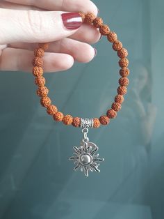 This unique bracelet with divine feminine vibes made of genuine small 5 Mukhi Rudraksha seeds beads and sun & moon charms.  You can wear this sacred beads bracelet in meditation and in your yoga practice, as well as in everyday life. You can wear this bracelet for protection, blessings, good fortune, health and well-being, and for spiritual evolution, or just because you like it :)  ! This bracelet is HANDMADE.  ! My Guru Pilot Babaji granted me the permission and blessing to make jewelry from Rudraksha for other people. ! Rudraksha that I use in my jewelry are high quality beads, real and genuine, from India. SYMBOLISM RUDRAKSHA in Sanskrit means "eye of Shiva" or "tears of Shiva". Rudra is one of the names of the Indian Lord Shiva. Rudraksha is known for its sacred and healing power: hea Adjustable Beaded Bracelets With Moon Charm, Handmade Hippie Bracelets For Meditation, Hippie Healing Bracelets With Round Beads, Spiritual Round Beads Charm Bracelet For Healing, Spiritual Charm Bracelet With 8mm Beads For Healing, Adjustable Spiritual Bracelets For Rituals, Adjustable Bohemian Beaded Bracelets With Moon Charm, Spiritual Handmade Beaded Bracelets For Festivals, Spiritual Beaded Bracelets For Festivals