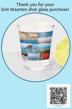 a glass with some pictures on it and a slice of lemon in front of it