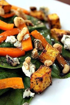 a white plate topped with spinach and carrots