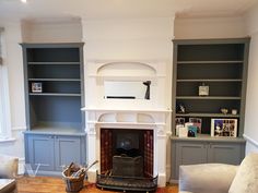 a living room filled with furniture and a fire place next to a book shelf on top of a hard wood floor