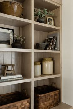 the shelves are filled with books and baskets