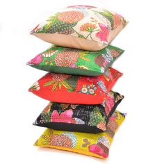 four pillows stacked on top of each other in different colors and patterns, one with a flowered design