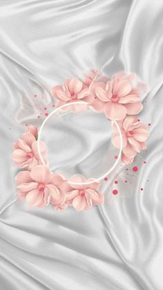 a white satin background with pink flowers on the corner and a circle in the middle