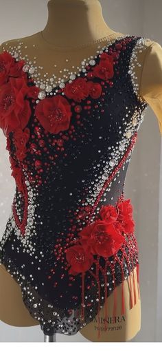 a woman's black and red dress with flowers on the front, white beading