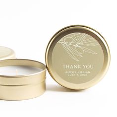 a candle that is sitting in front of a tin with the words thank you on it