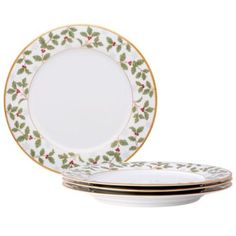 four plates with holly designs on them, one is white and the other has gold trim