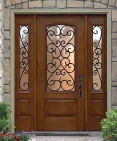 a wooden door with decorative iron work on the front and side panels, surrounded by flowers