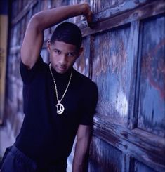 a young man leaning against a wooden door