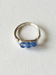 Triple Blue cultured sea glass silver plated wire wrapped ring. The silver plated wire is tarnish resistant And nickel and lead free. Beautiful blue colored glass to compliment any outfit. Made in Hawaii. Ships from Hawaii. The perfect gift for a loved one! This ring is a size 7 but one can be made in your size. Please specify size upon check out. Blue Sterling Silver Wire Wrapped Rings, Sea Glass Ring, Wire Wrapped Ring, Blue Sea Glass, Big Rings, Wire Wrapped Rings, Glass Rings, Wrap Rings, Blue Sea