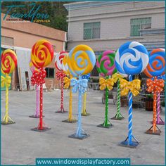 many colorful lollipops with bows on them are in the middle of a parking lot