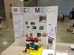 a table with a sign that says see me on it and some legos in front of it