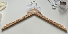 a pair of wooden clothes hangers with pearls on them