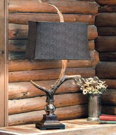 the antler lamp is next to a vase with flowers