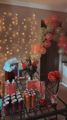 the table is set up with balloons, gifts and candy for someone's birthday