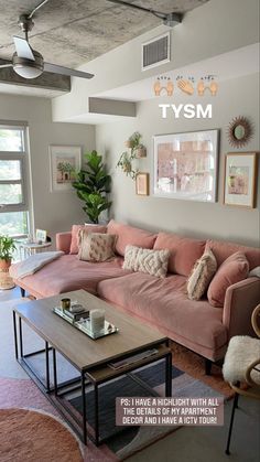 a living room with pink couches and pictures on the wall above them, along with a coffee table