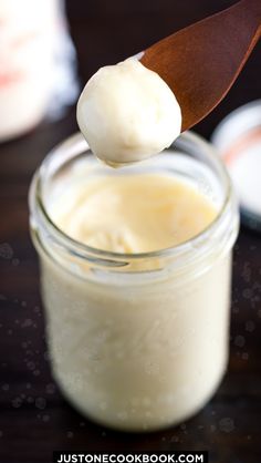 a spoon full of cream on top of a jar