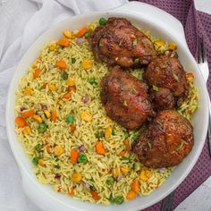 a white bowl filled with rice and meatballs on top of a purple table cloth