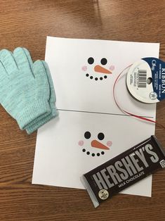 a pair of gloves and a candy bar on top of a paper snowman with hershey's logo