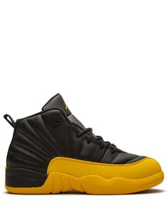 Black/university gold-tone leather/rubber Jordan 12 Retro sneakers from JORDAN featuring round toe, flat rubber sole, front lace-up fastening, branded insole and pull-tab at the heel. These styles are supplied by a premium sneaker marketplace. Stocking only the most sought-after footwear, they source and curate some of the most hard to find sneakers from around the world. | Jordan Kids Jordan 12 Retro sneakers Yellow High-top Jordan Shoes With Rubber Sole, Yellow Jordan Shoes For Streetwear, Jordans Kids Black, Jordan 12 University Gold, Jordan 12 Taxi, Kids Jordan, Drawstring Jeans, Yellow Nikes, Air Jordan 12