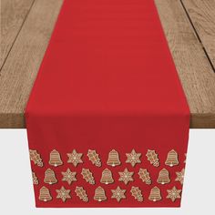 a red table runner with gold stars and bells on the top, along with a wooden bench