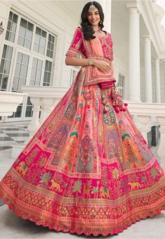 a woman in an orange and pink lehenga