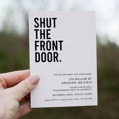 a person holding up a card with the words shut the front door printed on it