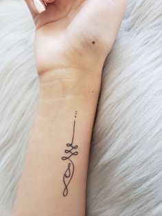 a woman's arm with a tattoo on it and an arrow in the middle