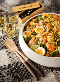 a white bowl filled with food next to two glasses