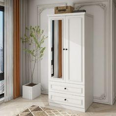 a white armoire sitting in front of a window next to a potted plant