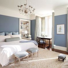 an image of a bedroom with blue walls and chandelier hanging from the ceiling