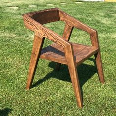 a wooden chair sitting on top of a lush green field