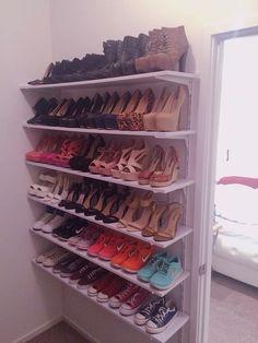 a white shoe rack with many pairs of shoes on it and the caption reads, keep shoes neat and off the floor with wall shelves